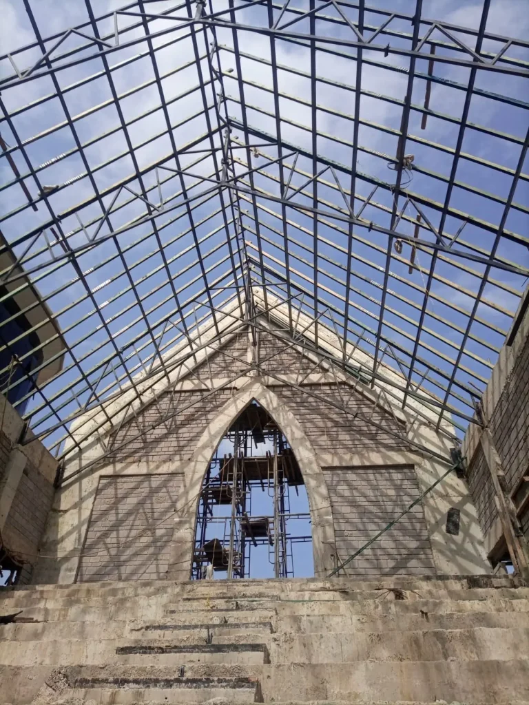 Steel trussed roof structure under construction at ACK St. James Cathedral Church in Kiambu County, showing 20-metre span steel trusses supporting a jack-roof system designed and supervised by structural engineers.