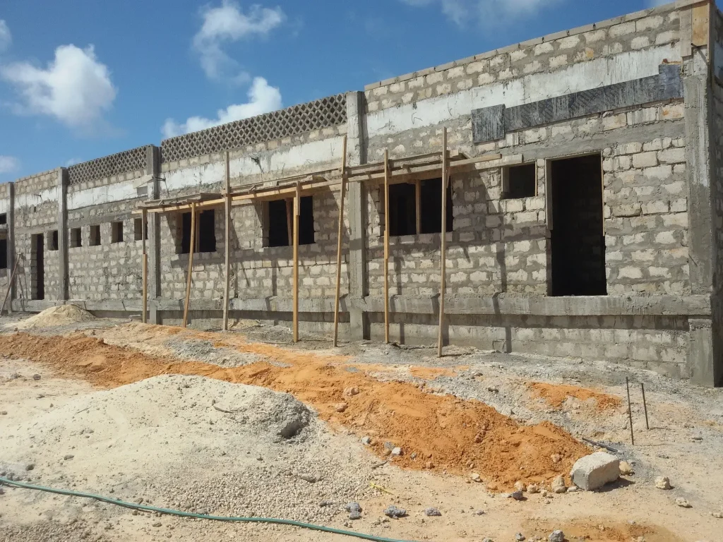 Completed low-rise hospital buildings at Xooga Hospital in Mogadishu, Somalia, showing external finishes, access paths, and ground preparation under civil and structural engineering supervision.